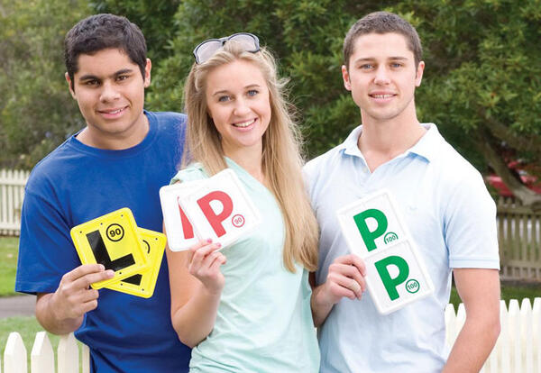 Young drivers holding up L and P plates