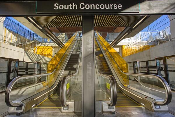 Bella Vista Escalators run from Bella Vista station to its south concourse. Lighting them up are brilliant sunflower yellow glass panels. In the background, the same yellow colour is seen on gloss-glazed tiles in the concrete retaining walls.