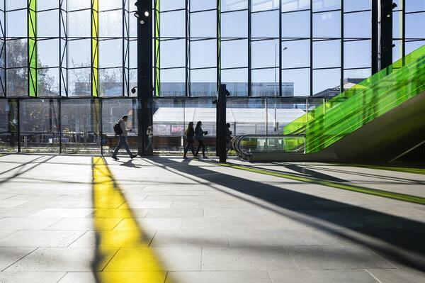 The concourse at Rouse Hill station is lit up by the sun shining through long vertical strips of apple green and lemon yellow glass panels. Through the day, the coloured light will wash over the concourse.