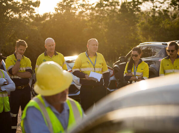 Work team in hi-vis gather for a briefing