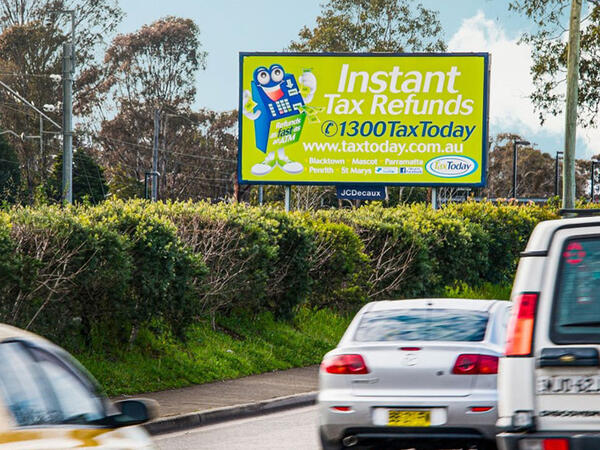 Digital billboards displaying vibrant advertisements along a busy roadside