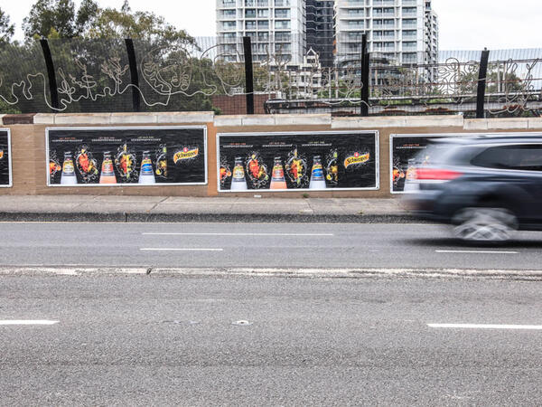 Billboards displaying vibrant advertisements alongside a busy road