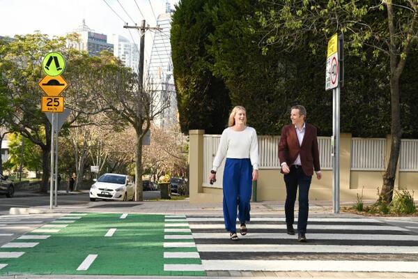 Two adults walking across pedestrian crossing