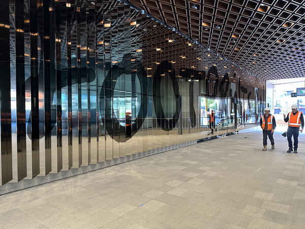 Footprints on Gadigal Nura by Nicole Monks. Aluminium lenticular panels with electroplated finish, 4.7 x 25m, Cast aluminium sculptures with electroplated finish, 16 x 24m, Photographic image in perforated aluminium panel, 9.7 x 9.7m. Images: Sydney Metro