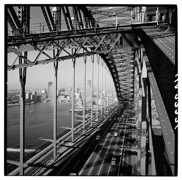 View through the Sydney Harbour Bridge arch towards Circular Quay, circa 1950