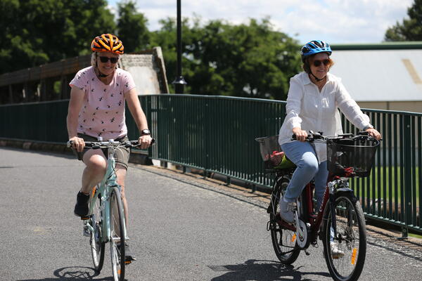 Two people riding bikes over a bridge in Bathurst