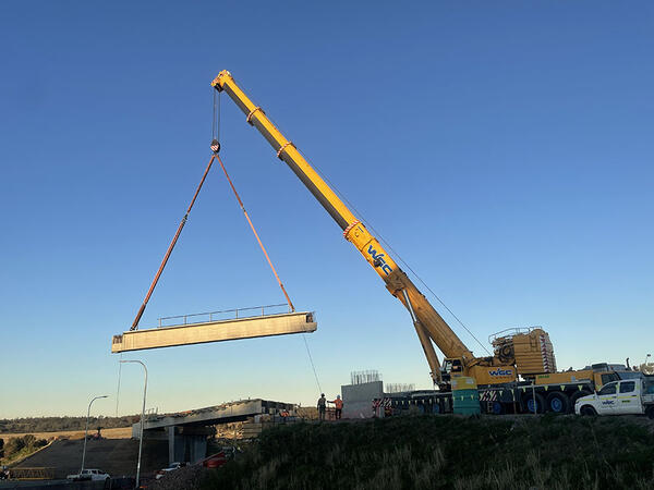 Crane carrying concrete beams