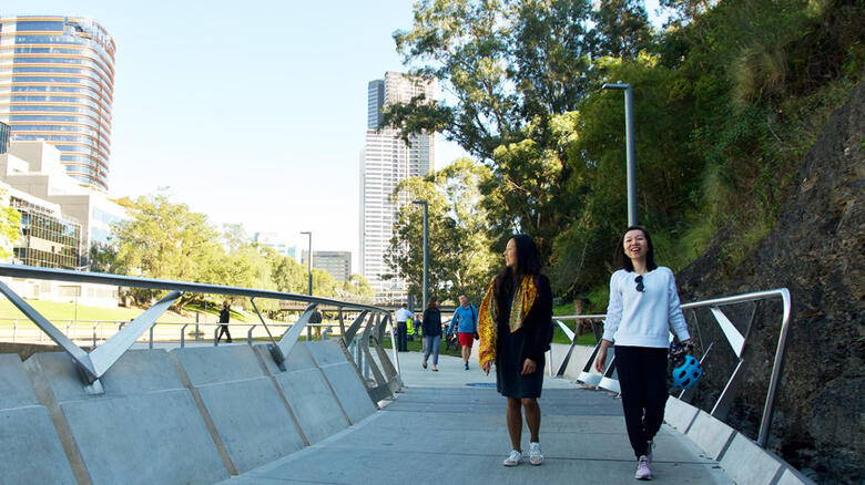 Two women walking along Parramatta River boardwalk