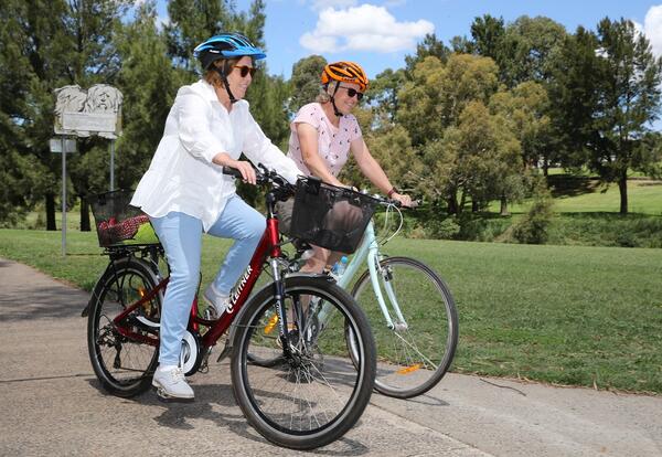 Two women cycling on a bike path
