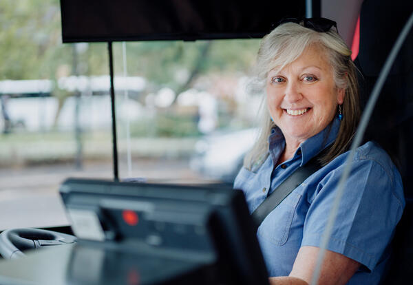 Female bus driver at the wheel smiling