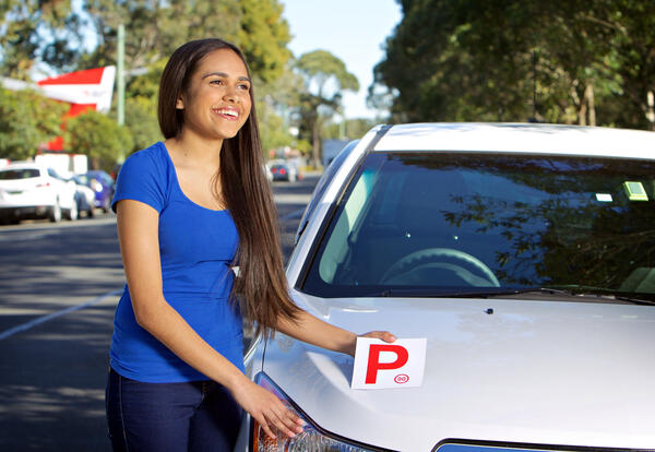 Young person holding a red P plate