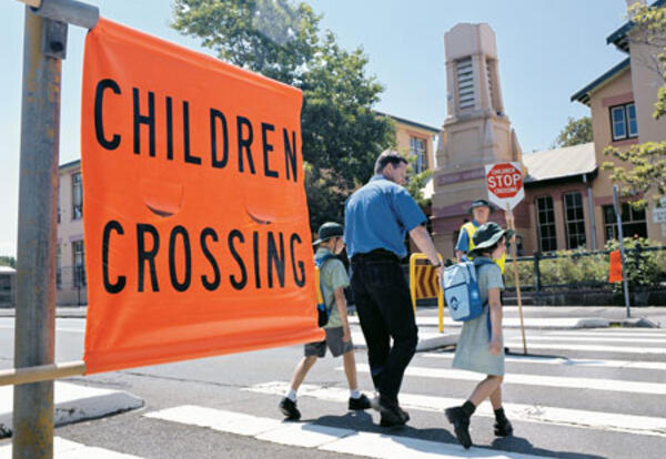 Parent and children crossing the road at a childrens crossing